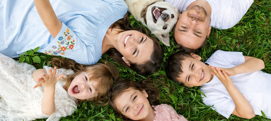 Family laying on grass in a circle